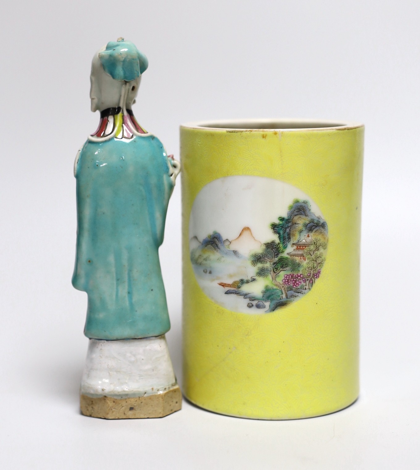 A Chinese yellow ground cylindrical brush pot, Republic period and a Jiaqing famille rose figure of a deity, tallest 16cm